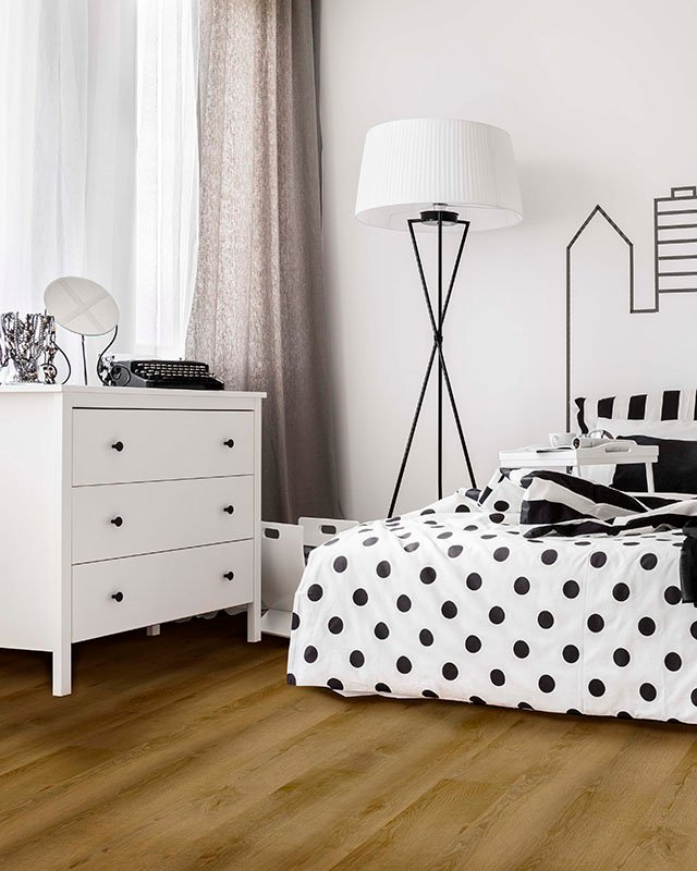 Bright bedroom interior with wide bed, commode and bedside cabinet